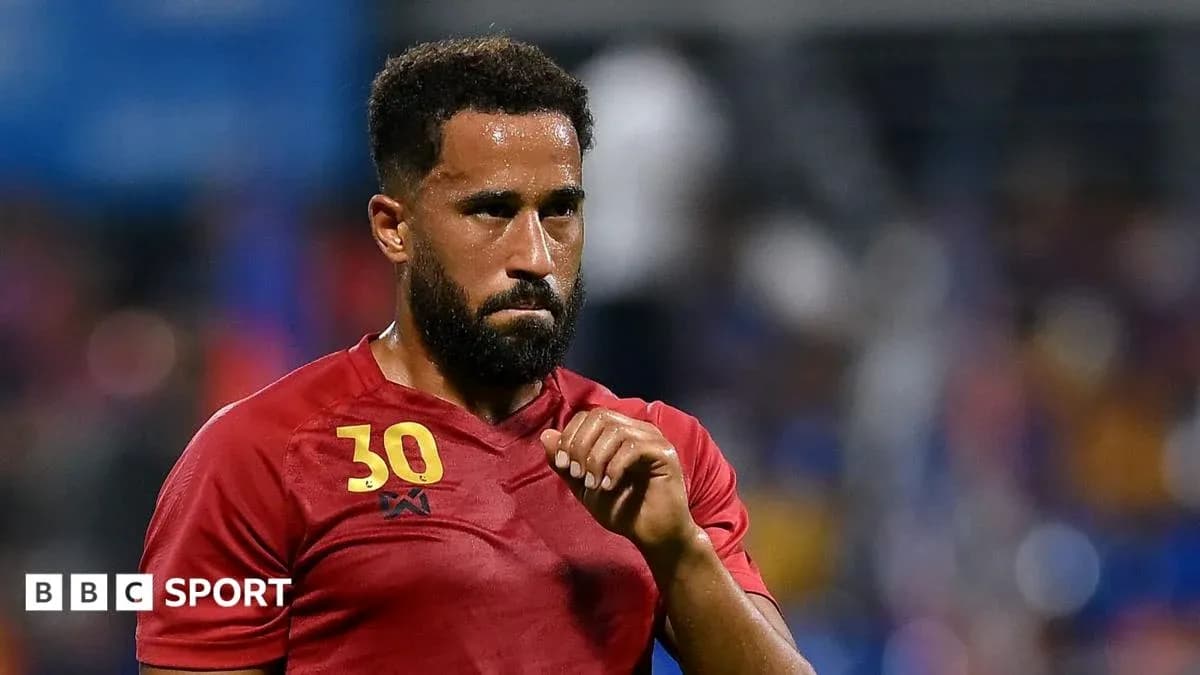 Player in red jersey during match with focus