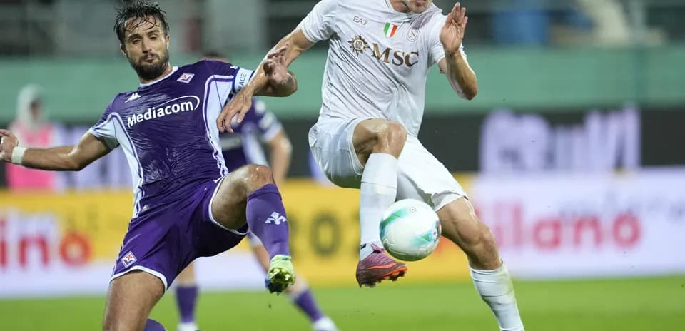 Fiorentina player challenges Napoli opponent for the ball