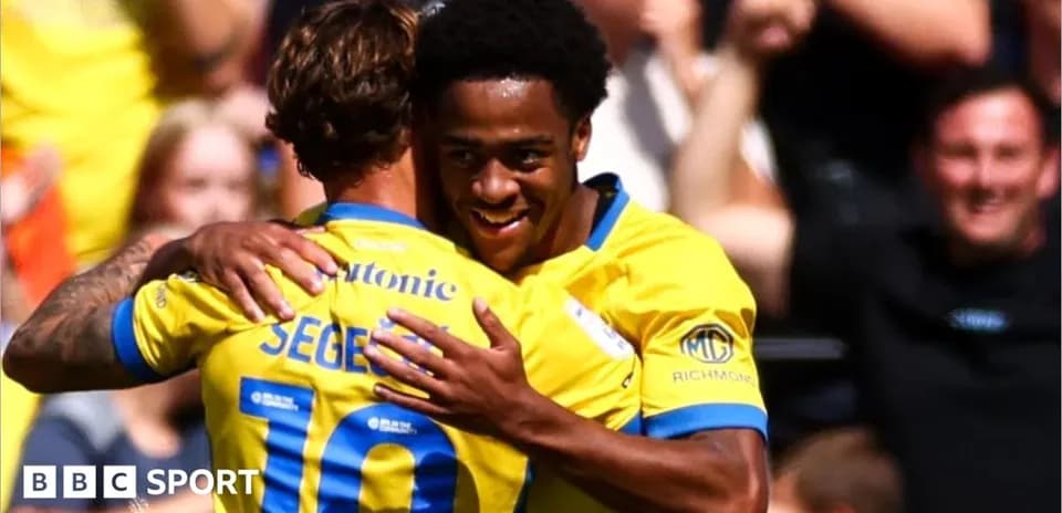 Players celebrating a goal with an embrace