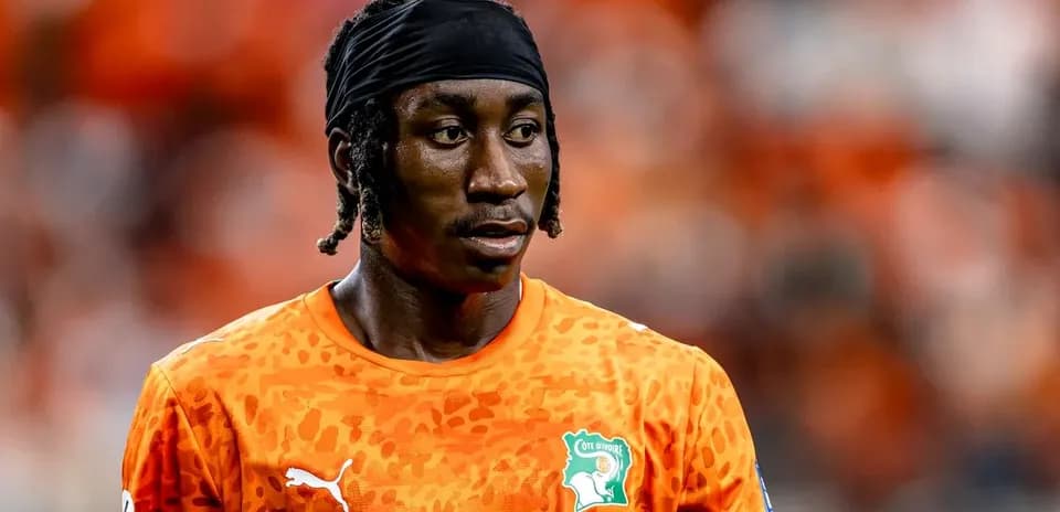 Player in orange kit during match warm-up