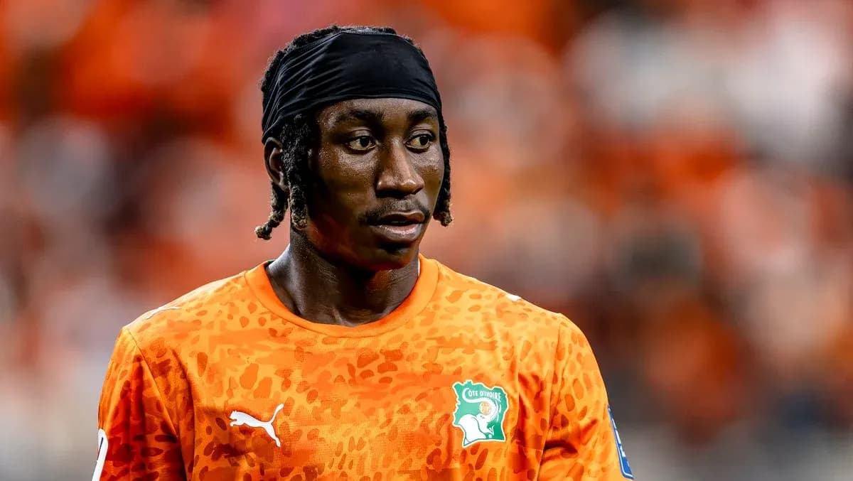 Player in orange kit during match warm-up