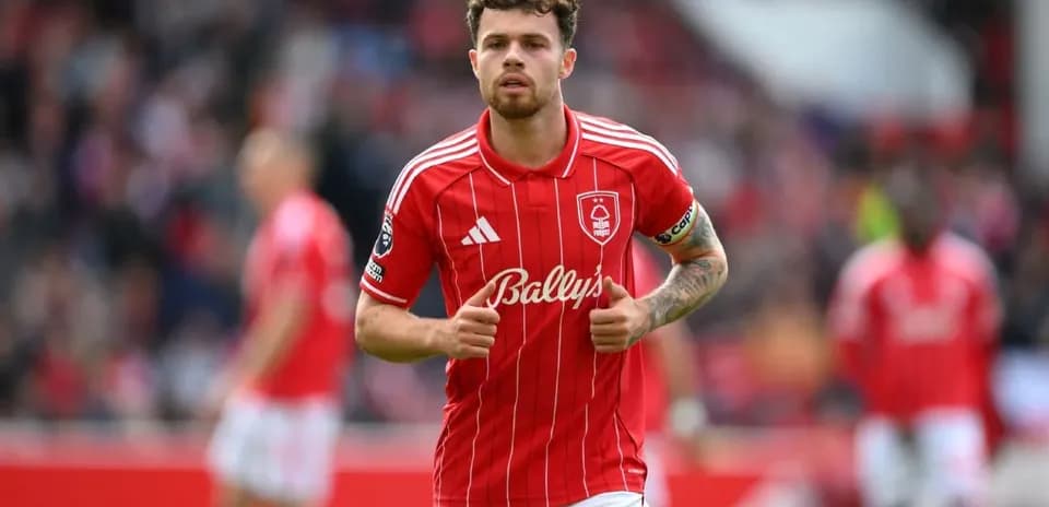 Player in red kit walking on the pitch