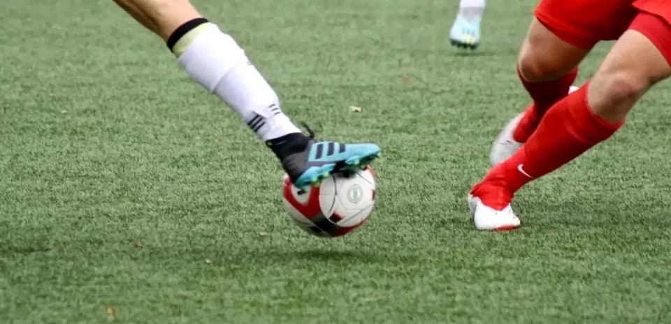 Two players contesting for the ball in football