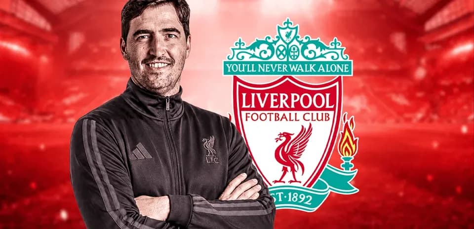 Coach standing in front of Liverpool FC logo