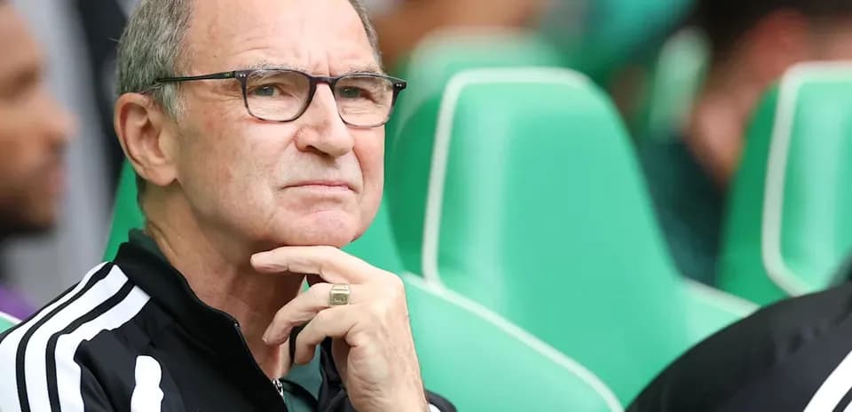 Coach observing match from sidelines with thoughtful expression