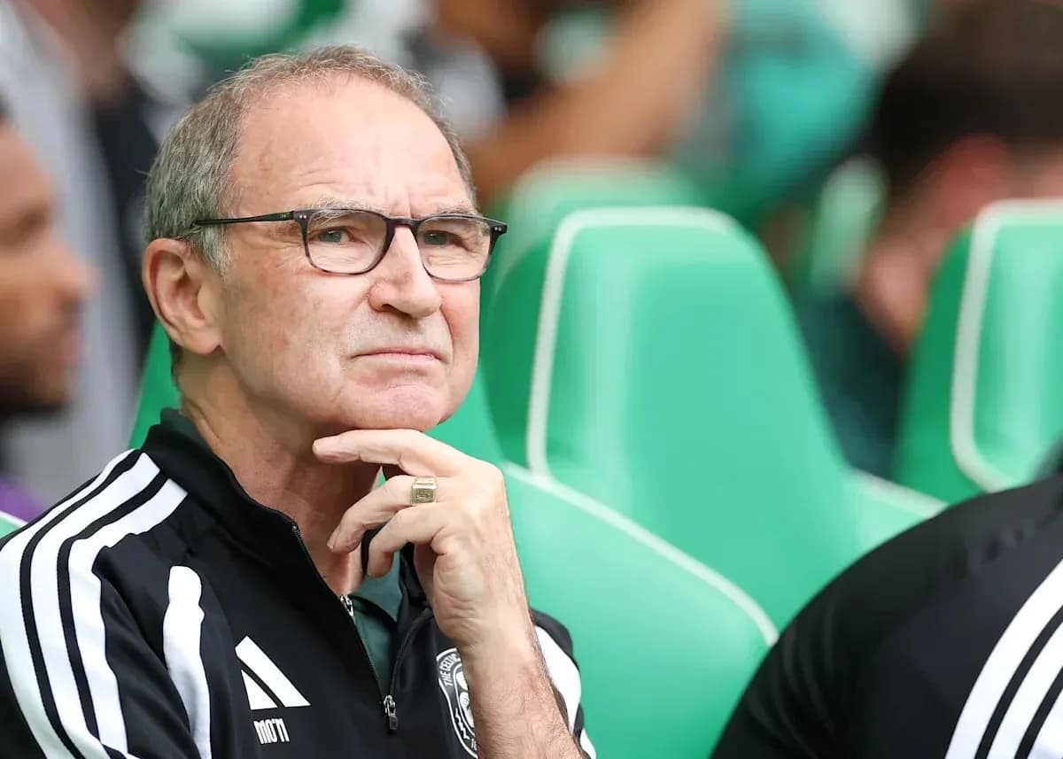 Coach observing match from sidelines with thoughtful expression