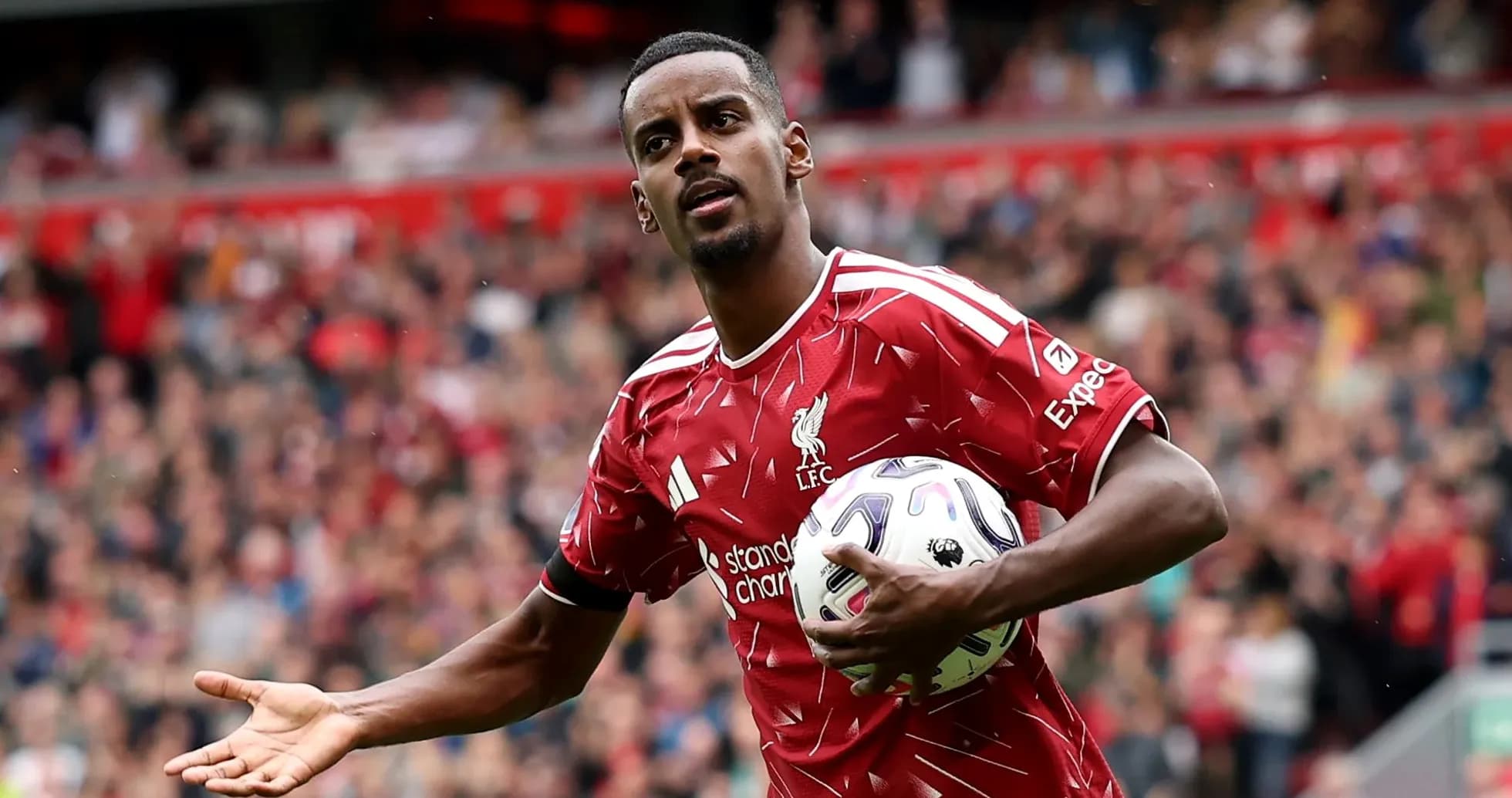 Player in red Liverpool kit holding a soccer ball