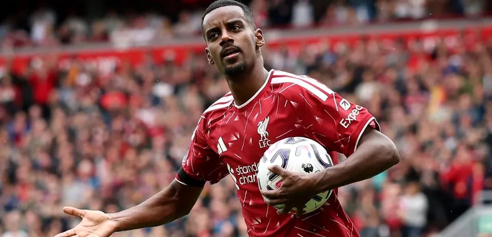 Player in red Liverpool kit holding a soccer ball