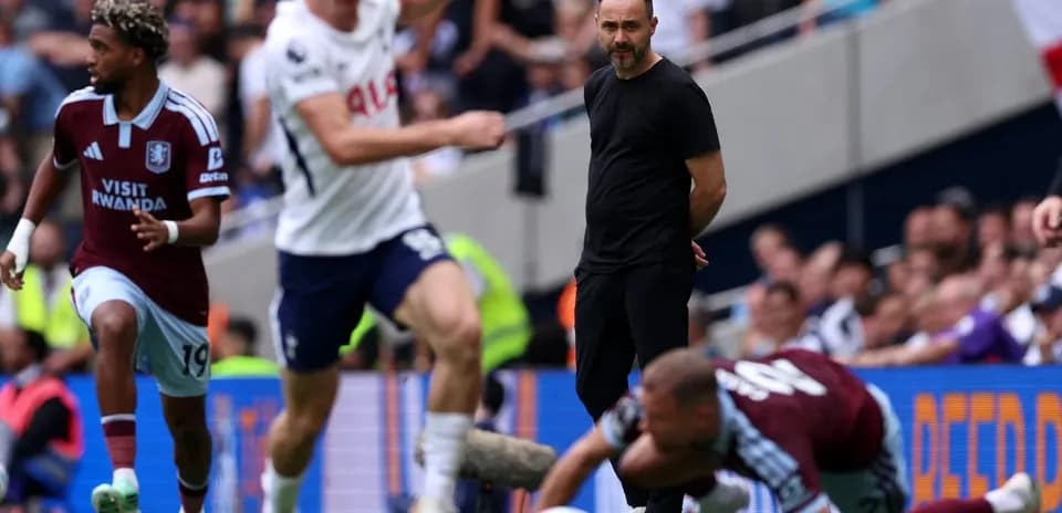 Aston Villa player running during match, coach observing