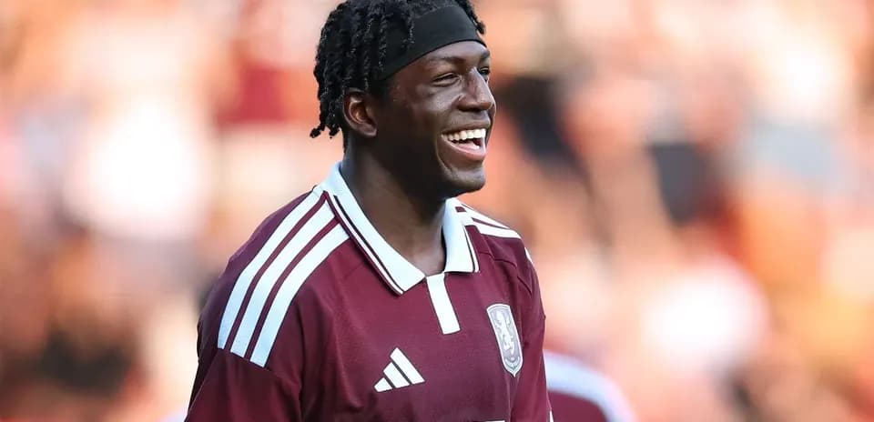 Player smiling in maroon team jersey on field