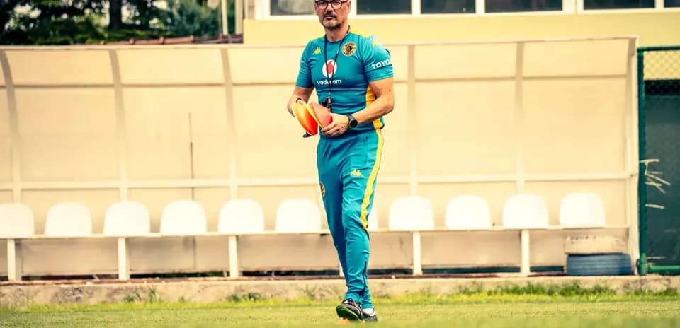 Coach walking on field holding training cones