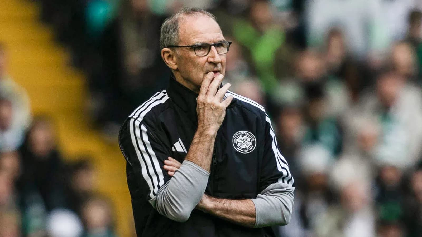 Manager observing match with arms crossed