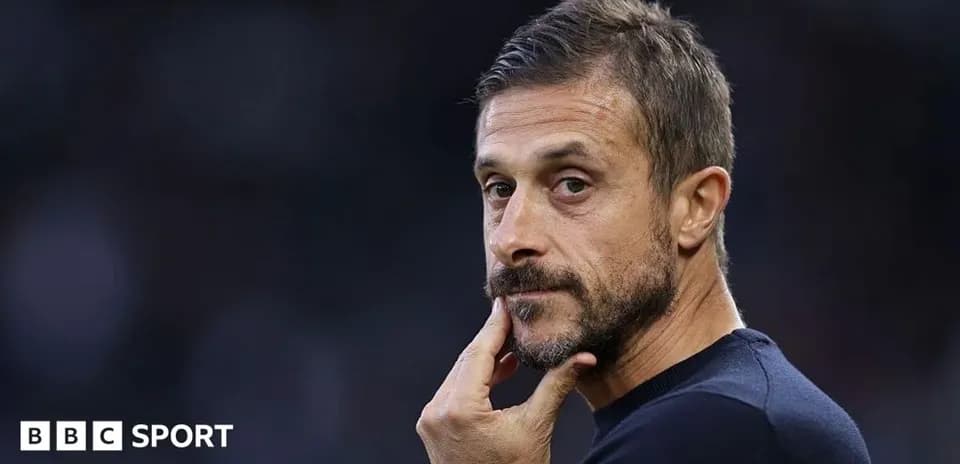 Coach observing the match with a thoughtful expression