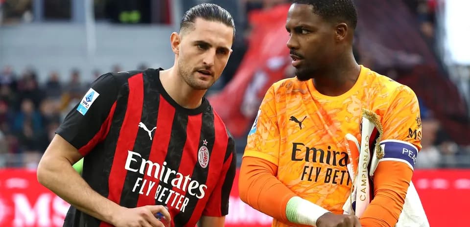 Two AC Milan players discussing on the pitch