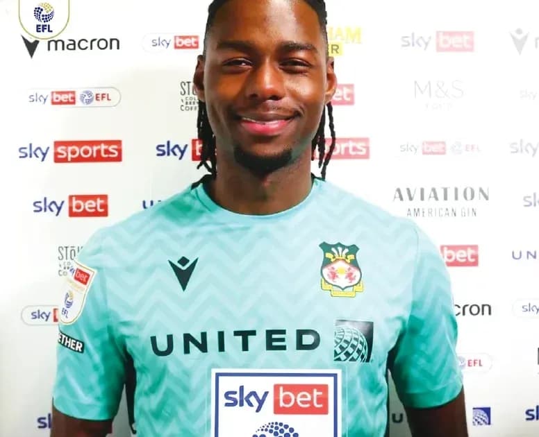 Goalkeeper in team kit smiling for photo