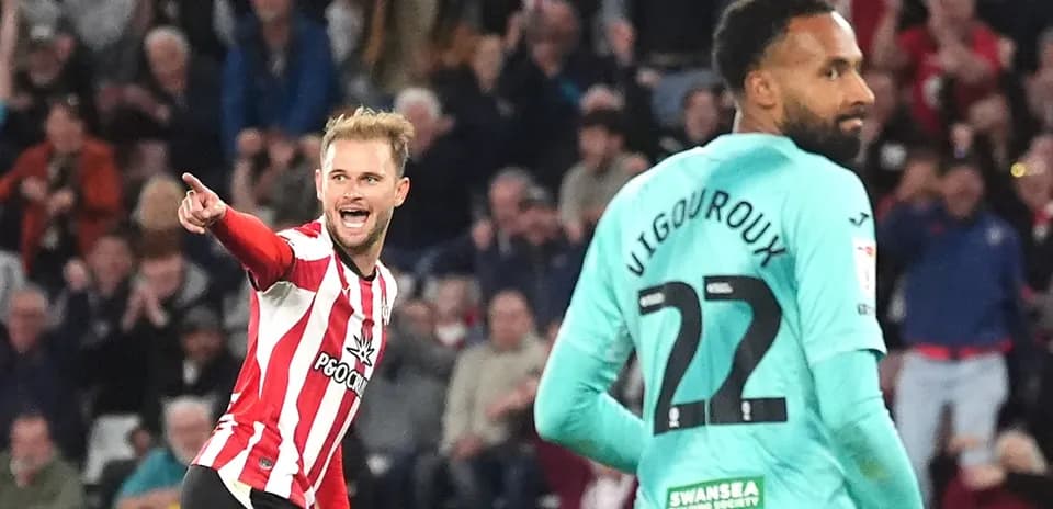 Player celebrating a goal while another looks on