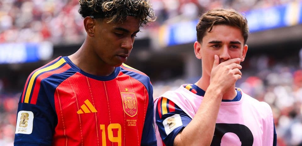 Two Spanish players walking off the field