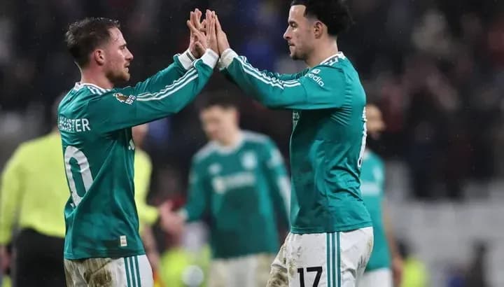 Two players celebrating with high-five on pitch