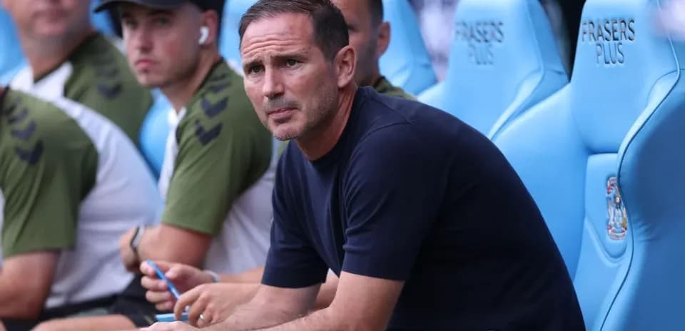 Manager seated on bench during a match