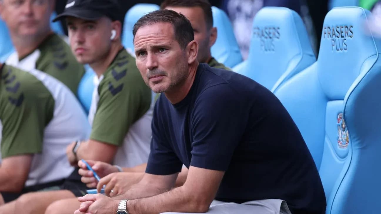 Manager seated on bench during a match