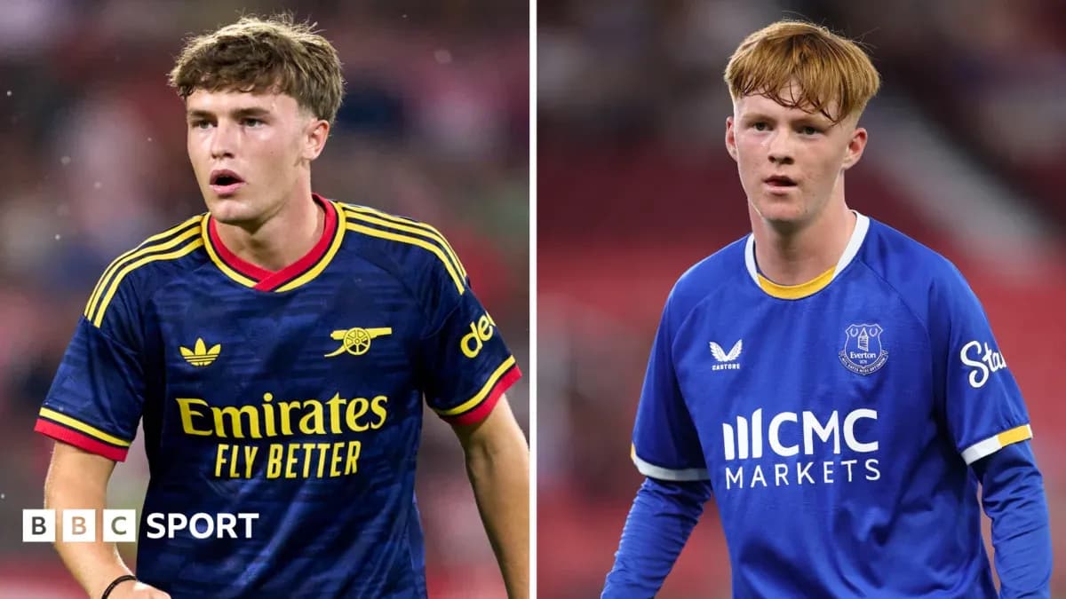 Two young footballers in team kits on the field