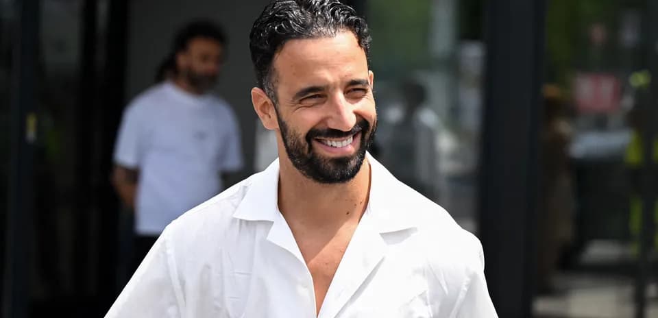 Smiling man in white shirt walking outside building