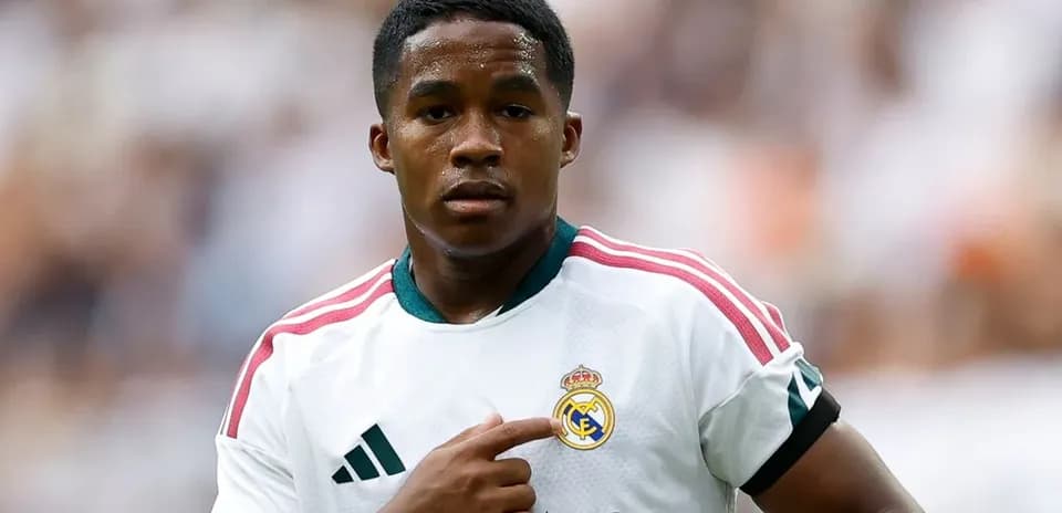 Player pointing to Real Madrid club logo on jersey
