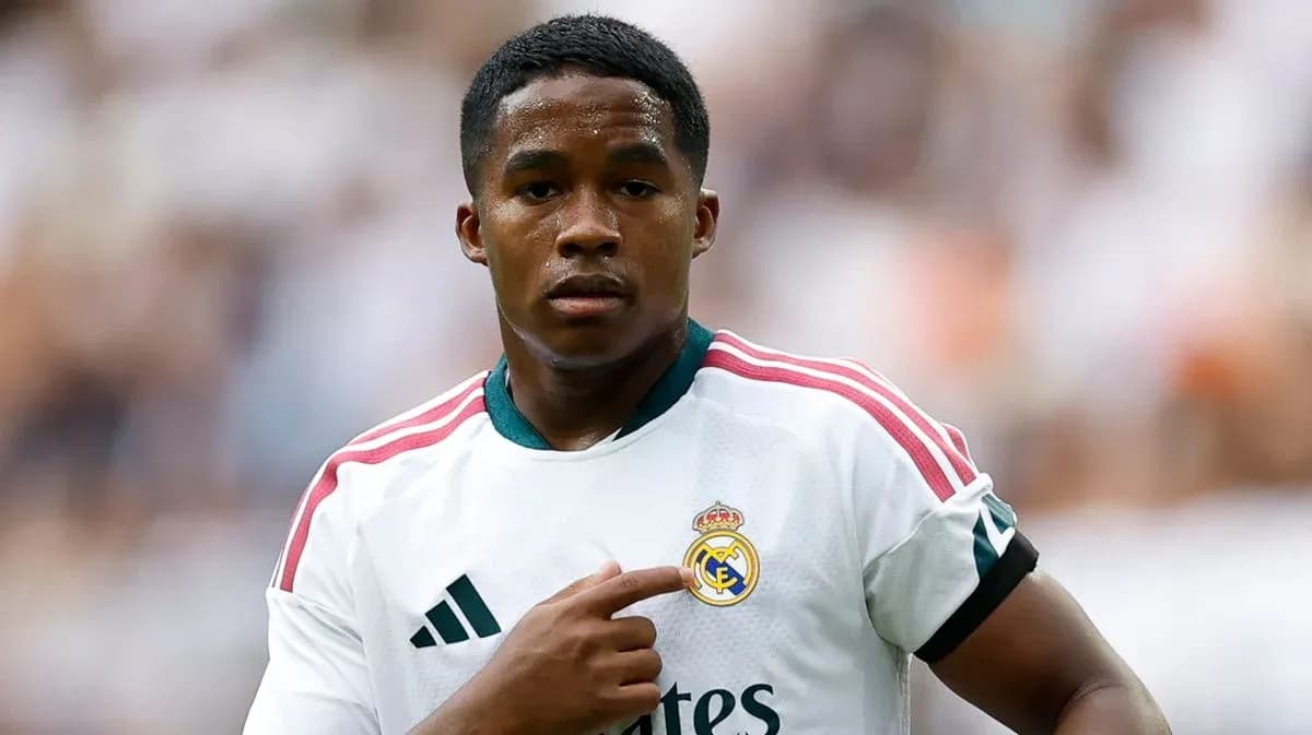 Player pointing to Real Madrid club logo on jersey
