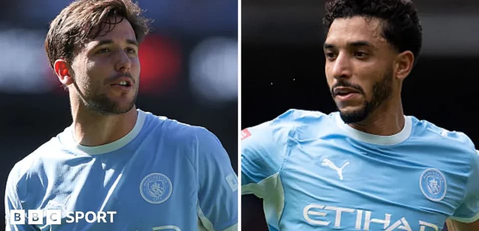 Two Manchester City players in blue jerseys