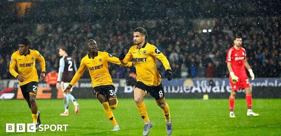 Player celebrating a goal in rainy football match