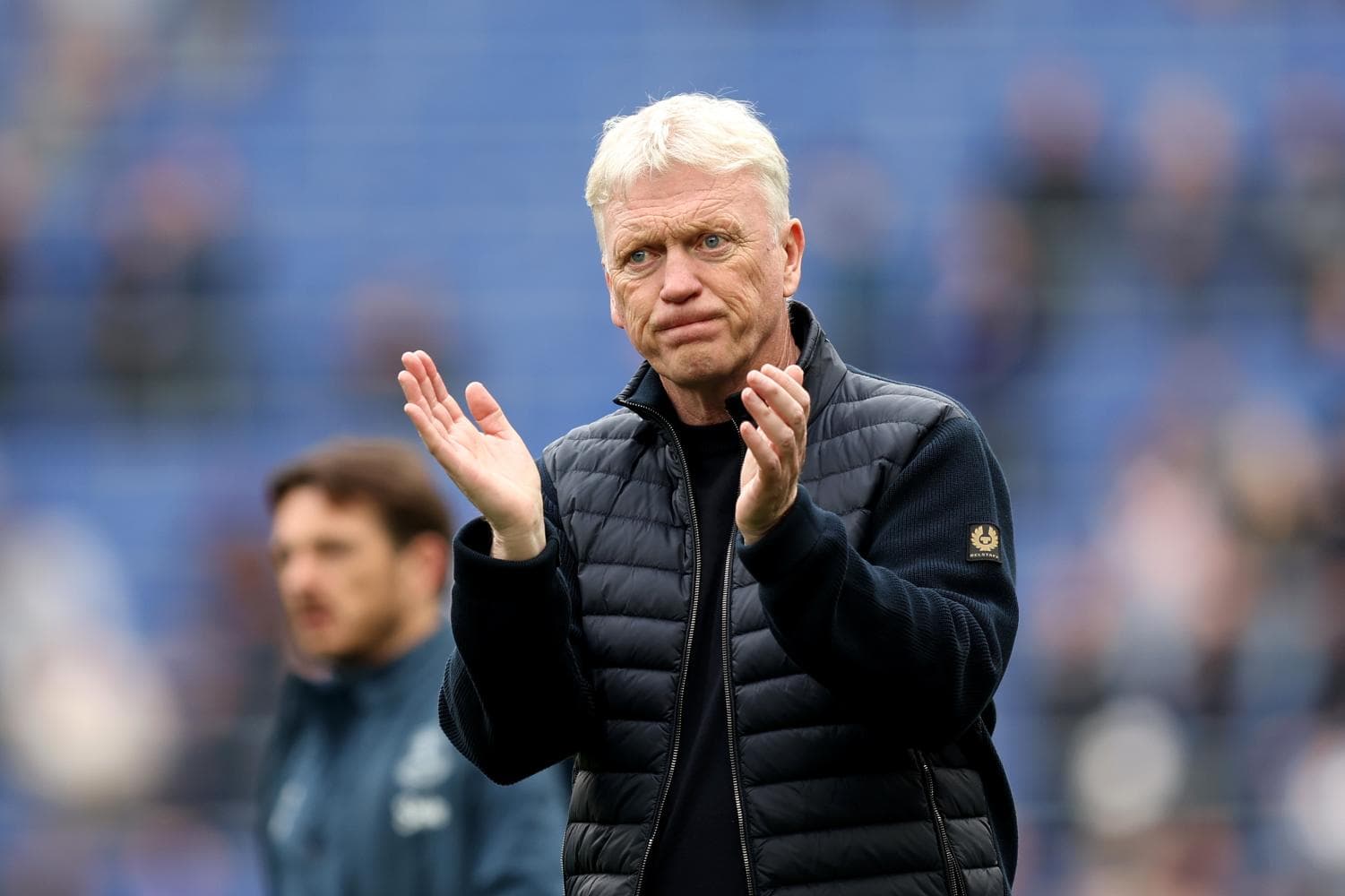 Manager clapping on the sideline during match
