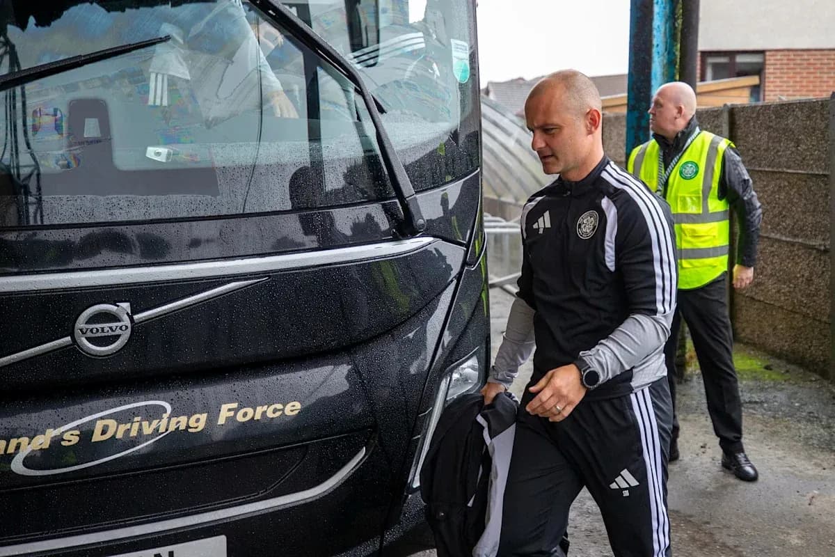 Coach and staff arriving at team bus in rain
