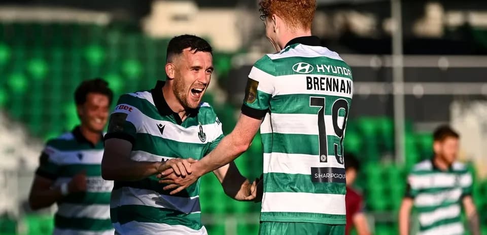 Players celebrating a goal in green and white jerseys
