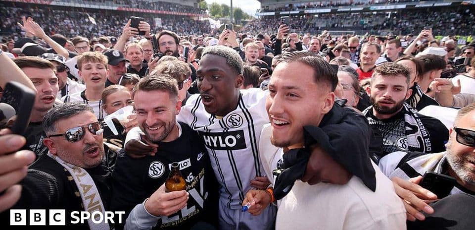 Fans celebrating with players on the pitch