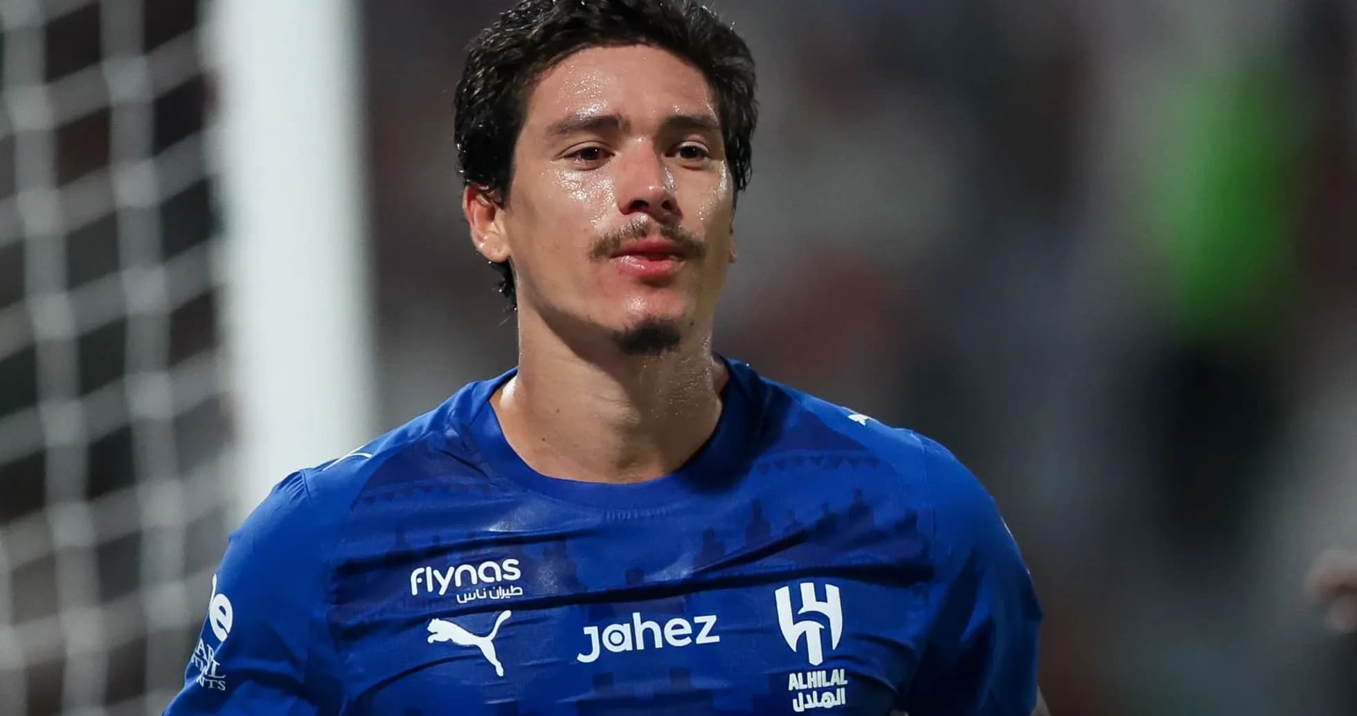 Player in blue jersey walking on the field