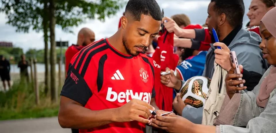 Player signing autographs for fans at event