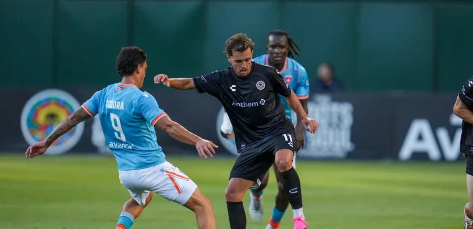 Player dribbling past opponent during USL match