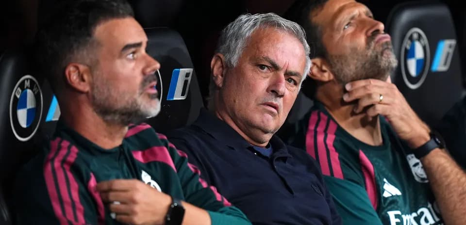 Coaches seated on bench during a match