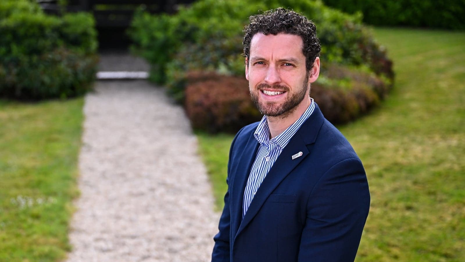 Man in suit standing on garden pathway