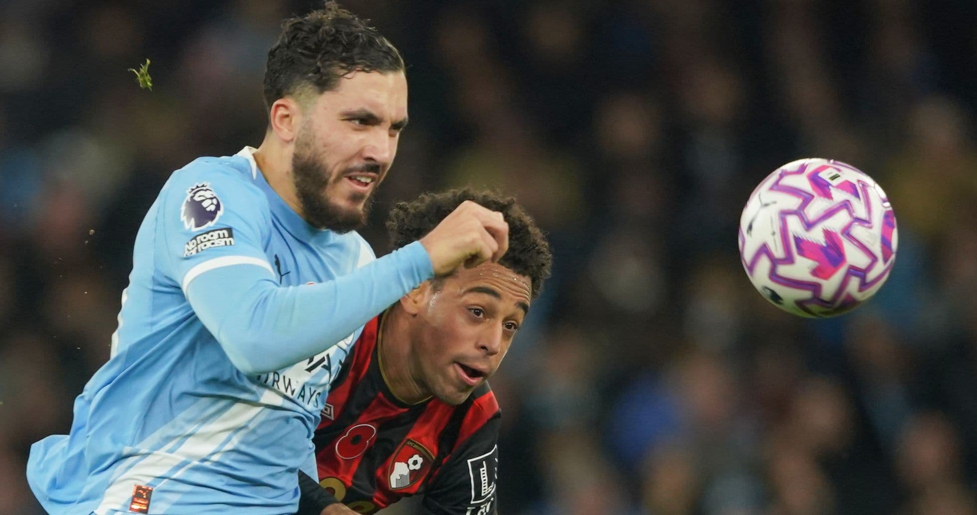 Bournemouth player challenging Manchester City opponent