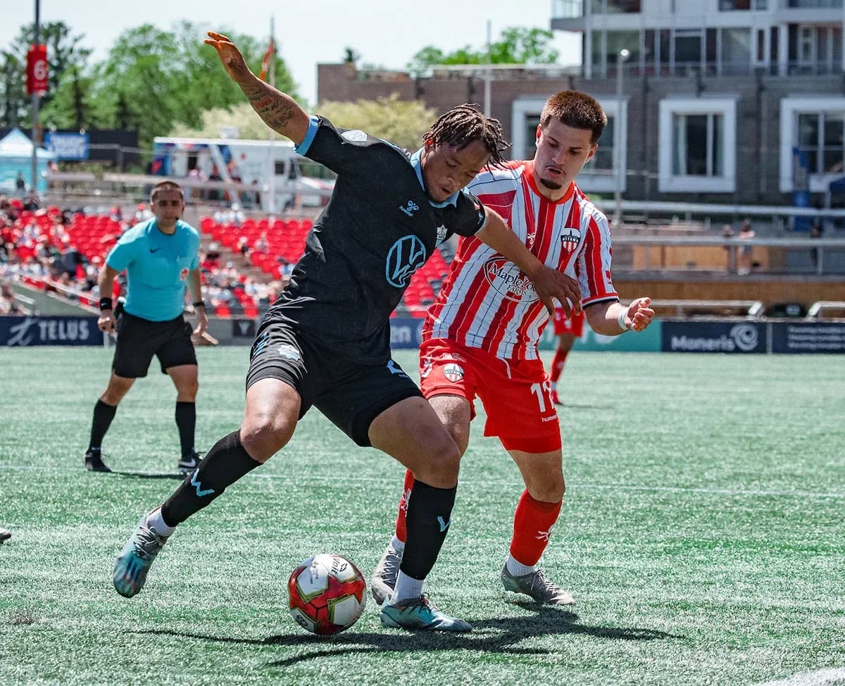 HFX Wanderers player tackling Atlético Ottawa opponent