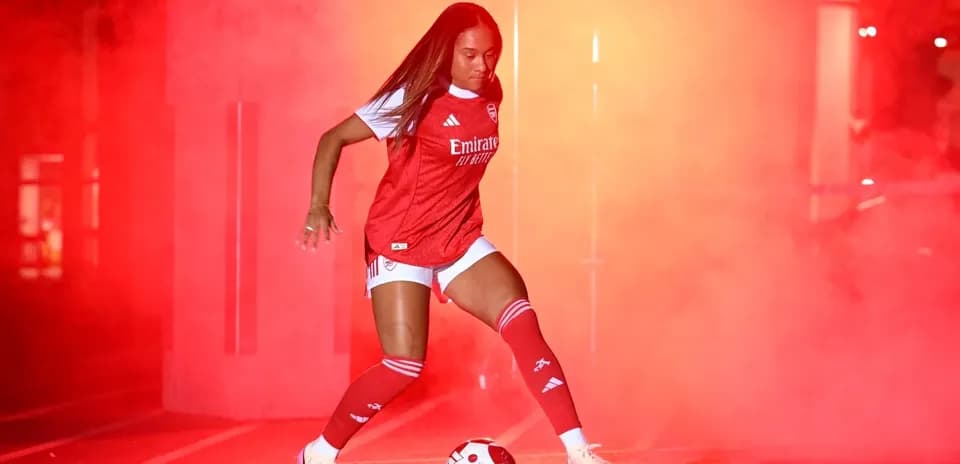 Player in Arsenal kit with soccer ball in smoke