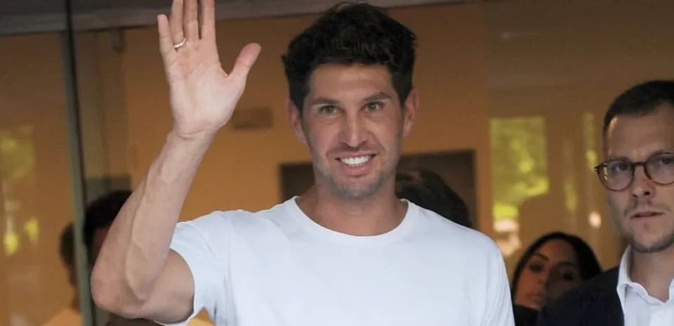 Man waving while standing with others indoors