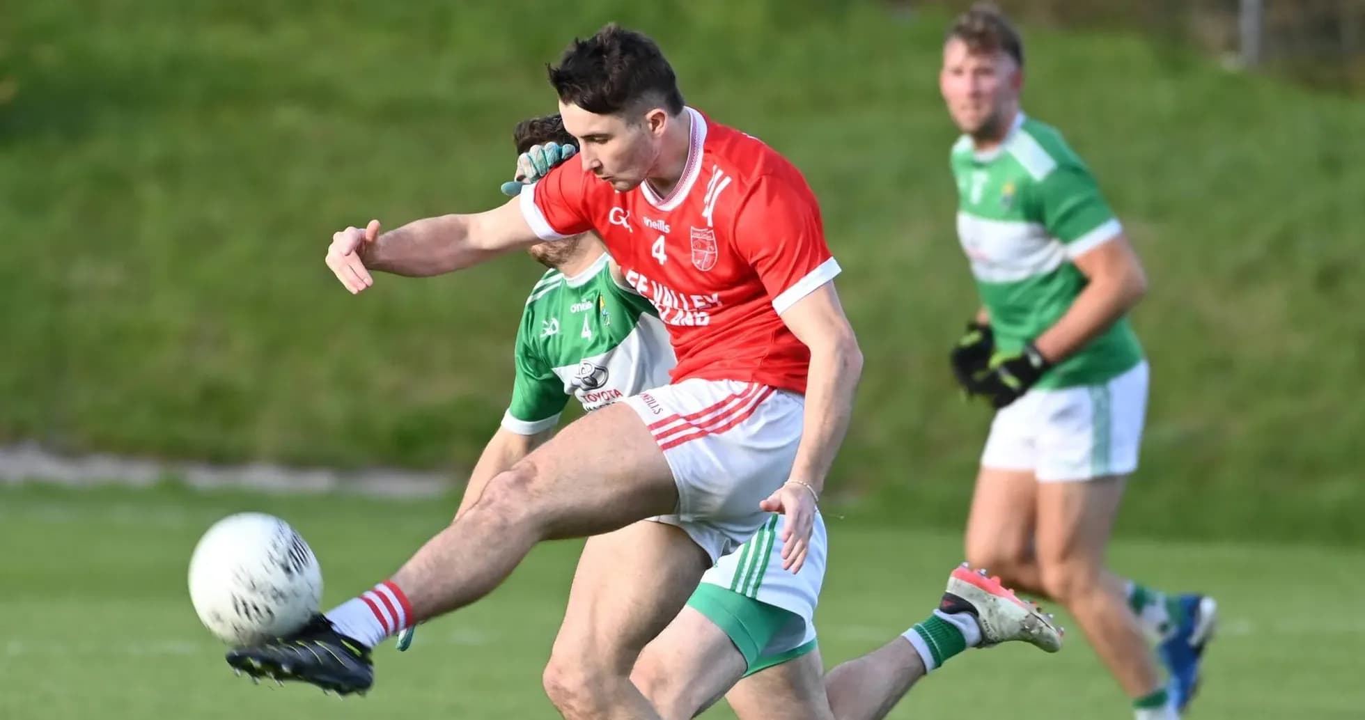 Player kicking the ball during a Gaelic football match