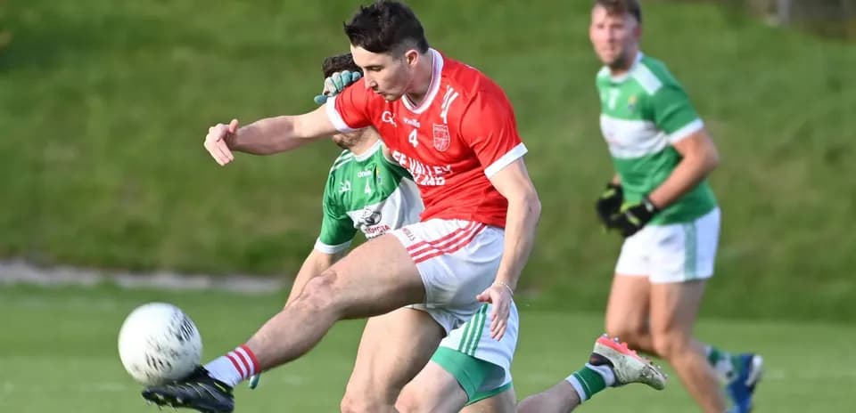 Player kicking the ball during a Gaelic football match