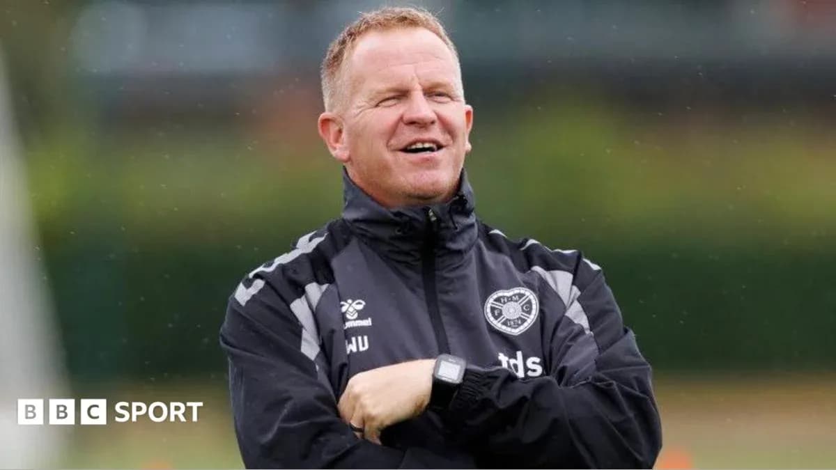 Coach standing with arms crossed during training session