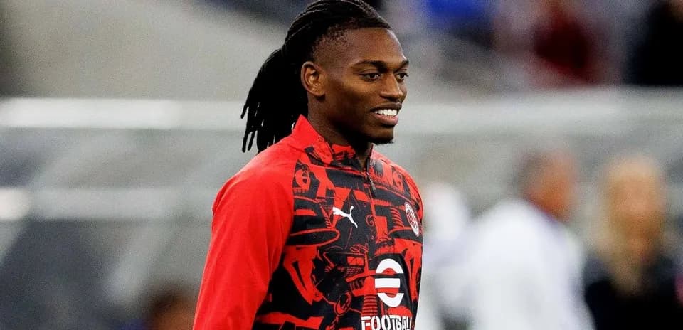 Player in red training gear smiling on the field