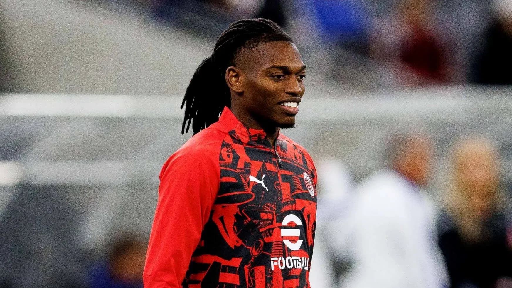 Player in red training gear smiling on the field