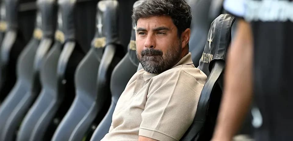 Coach sitting on bench during match preparations