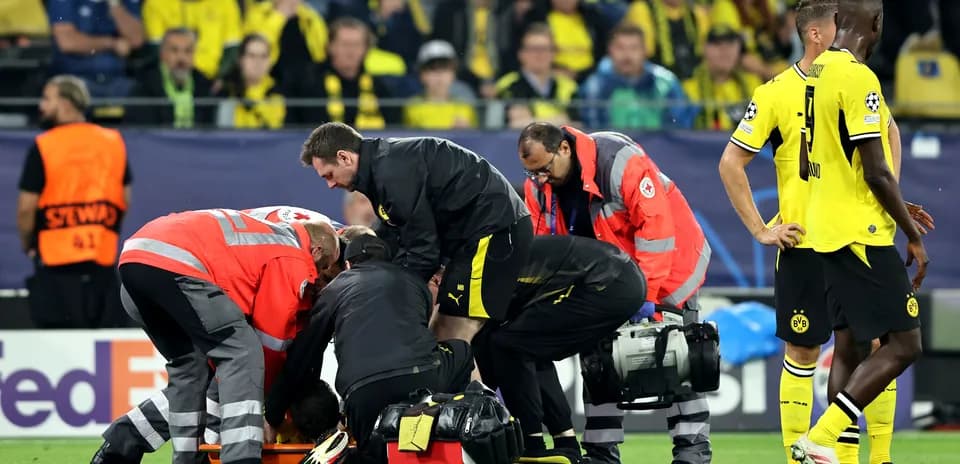 Medical staff attending to injured player on pitch